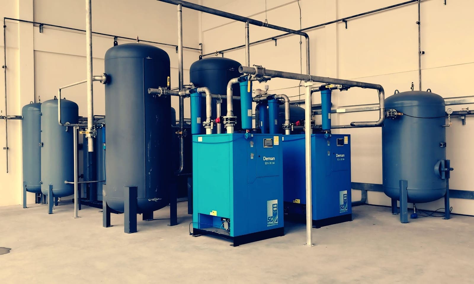 A compact refrigeration unit with hose fittings on a hard floor
